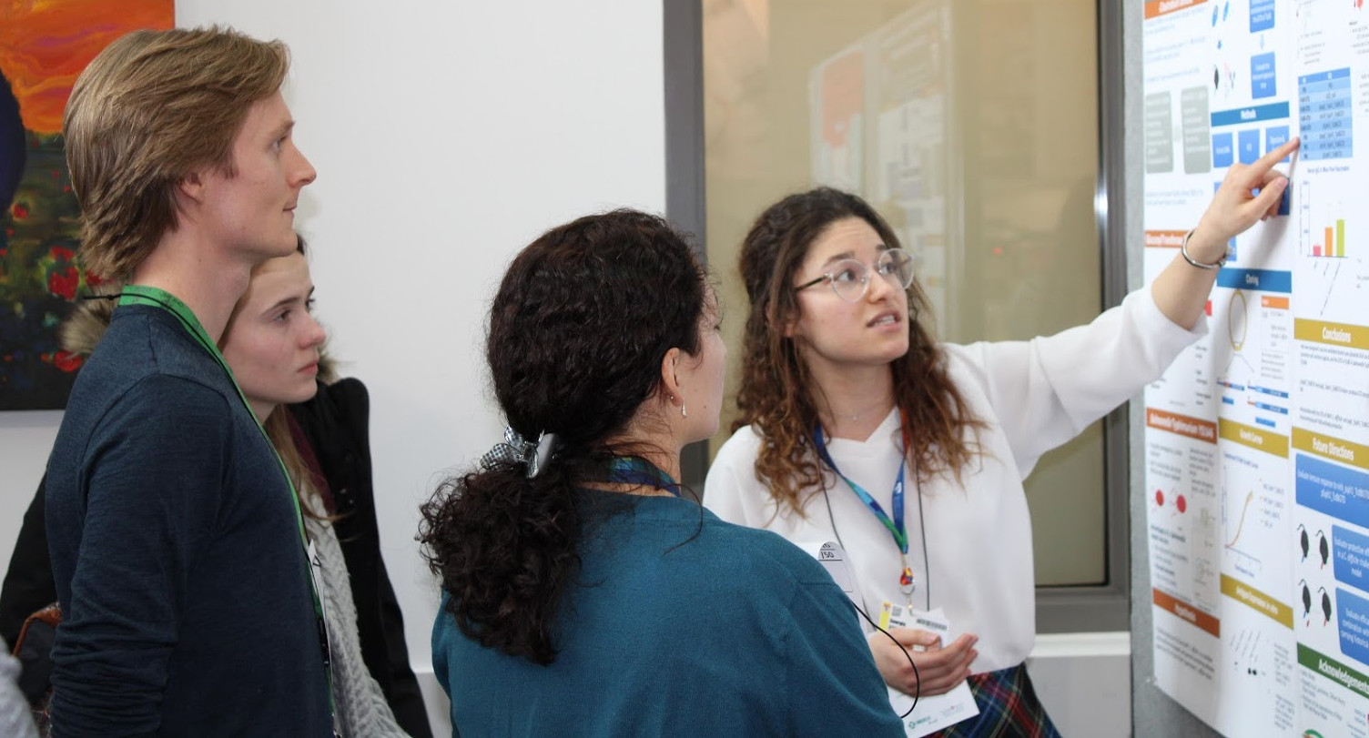 IDIGH members in front of a poster. 